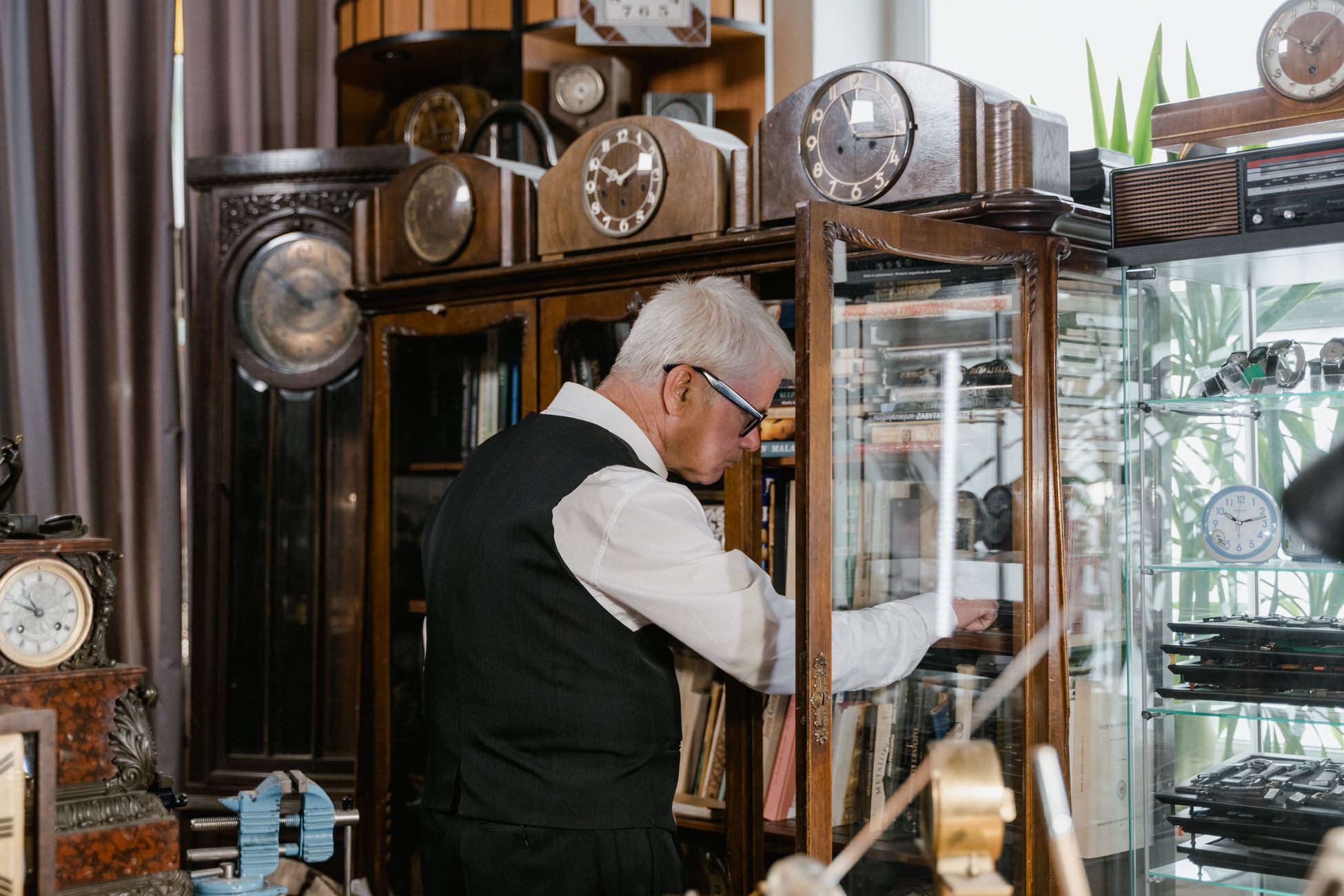 Clock collector examining a display cabinet